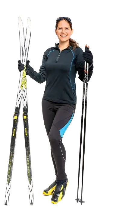 MMag. Anita Schmidt-Pöstion ist in Langlaufmontur mit Skiern und Stöcken ausgest