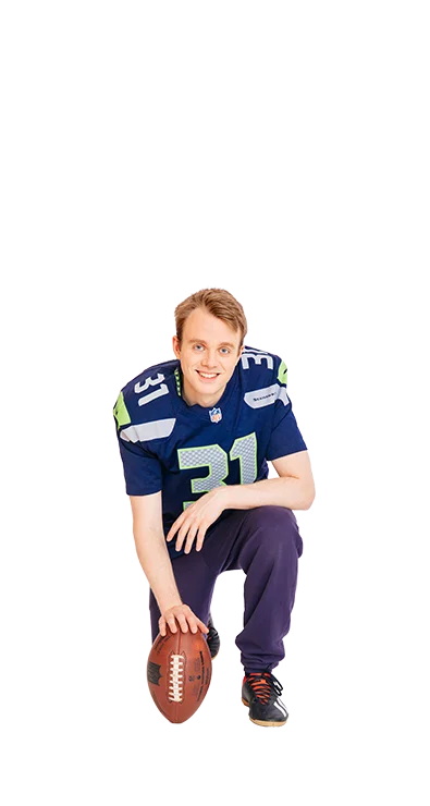 Jan-Michael Bussmann, MSc kniet im American-Football-Outfit mit einem Football i