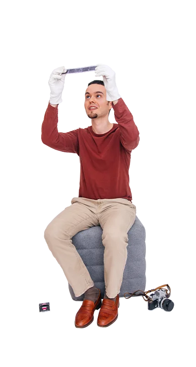 Jan-Bartl Koncel, MSc (WU) sitzt auf einem Hocker und trägt weiße Handschuhe, wä