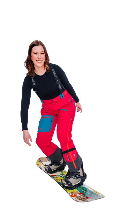 Lena Hammer, MA fährt in knallroter Skibekleidung auf einem Snowboard, lacht in 