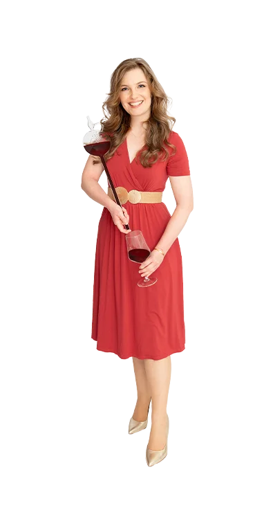 Viktoria Groiss, MA hält ein Weinthermometer in der einen und ein Weinglas in de